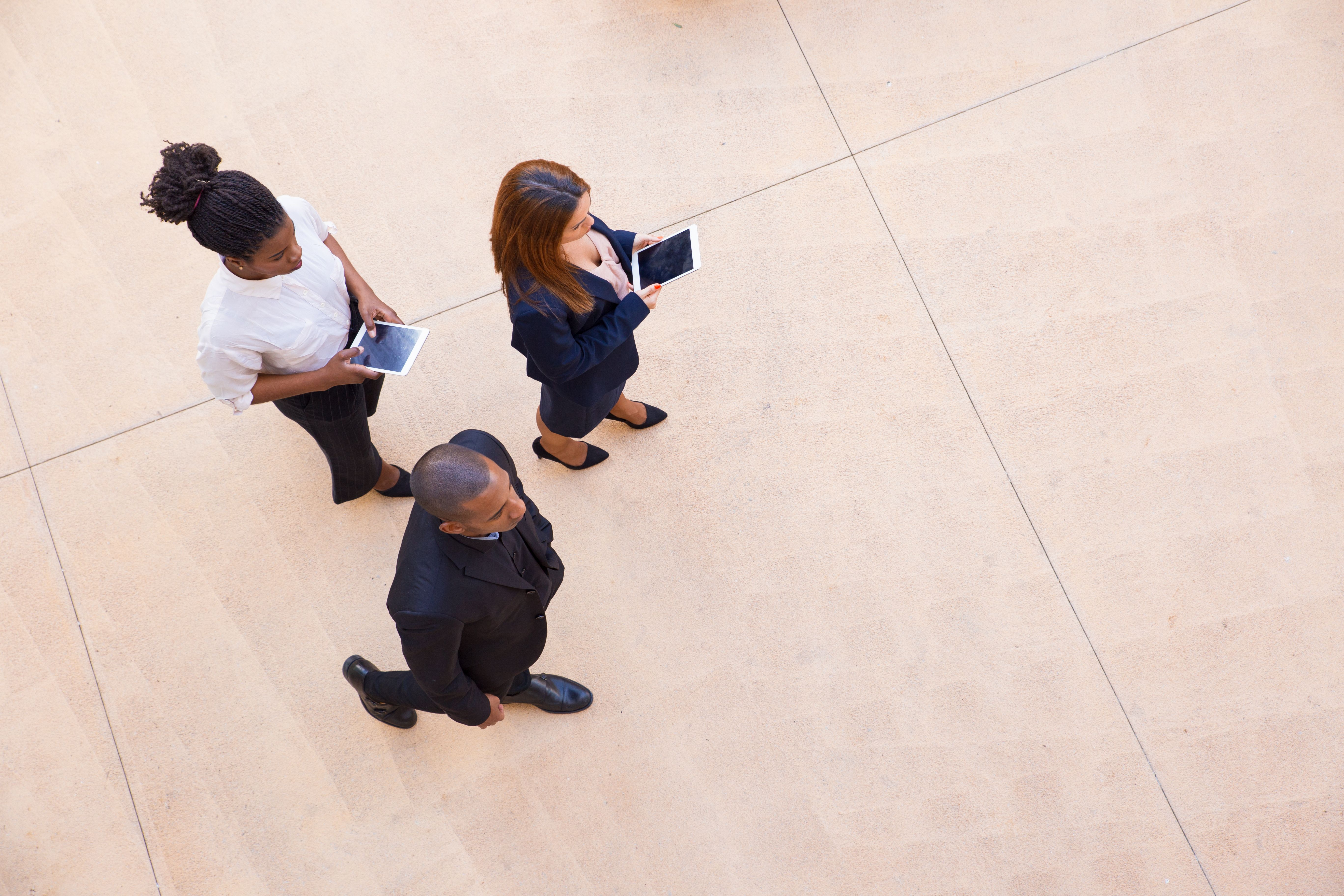Business leader with his female assistants walking through office