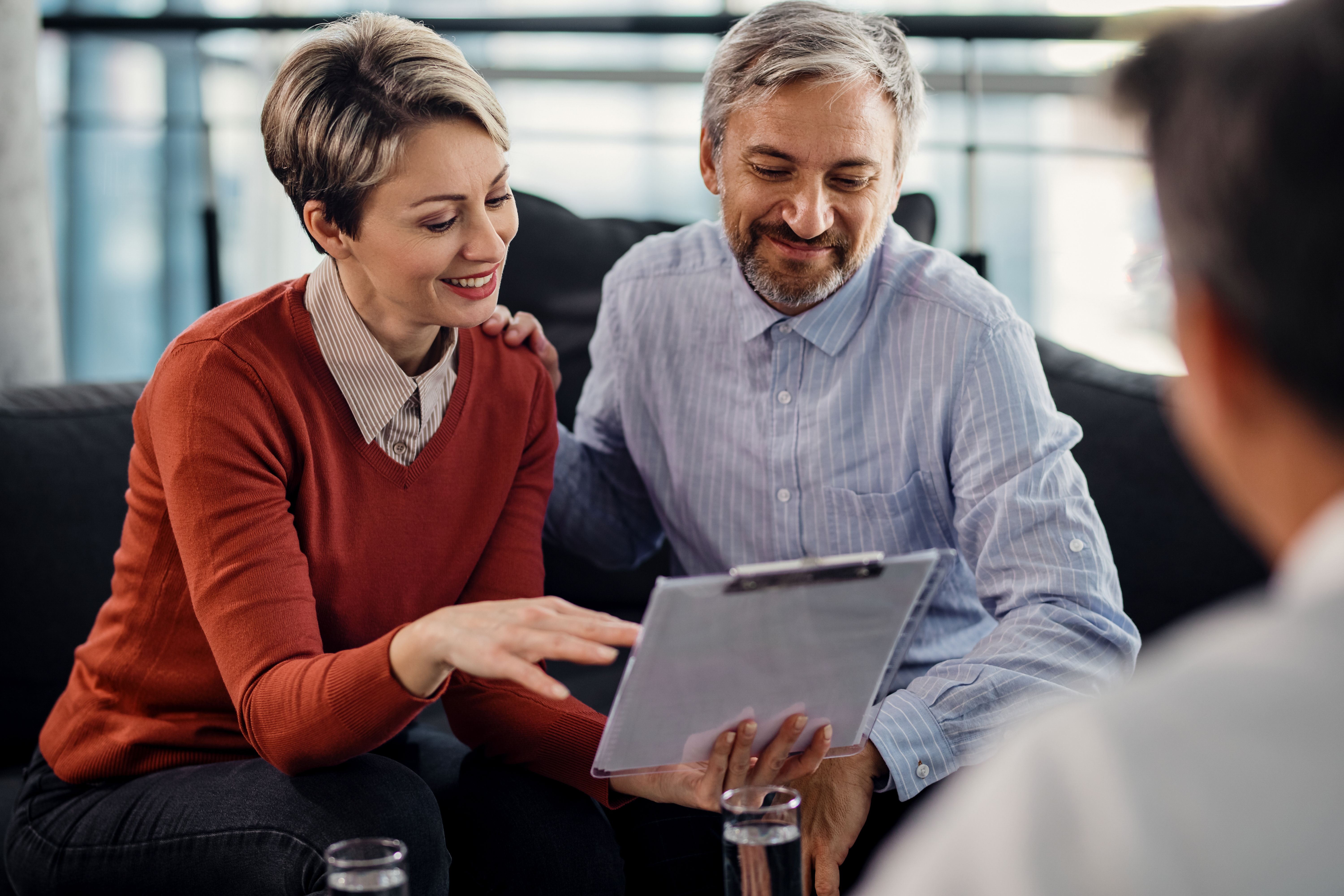 Happy couple going through terms of agreement meeting with financial advisor